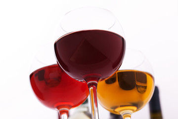 Glasses and bottles of wine unusually on white background.
