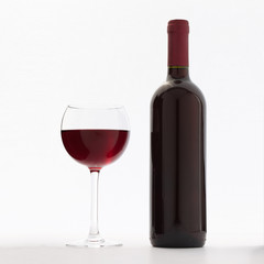 Glass and bottle of red wine unusually on white background.