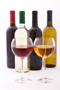 Glasses and bottles of wine unusually on white background.