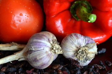 still life of fresh vegetables and dried barberry with drops of water on a dark background

