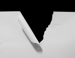 Hole ripped in white paper