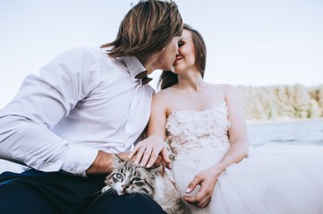 beautiful young wedding couple on a boat with a cat