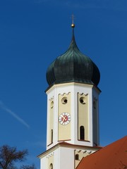 Zwiebelturm im Barockstil der katholischen Kirche St. Cosmas und Damian vor blauem Himmel im...