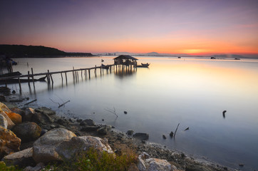 Silhouette of fisherman cottage during sunrise.