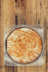 calzone in plastic bag on brown background