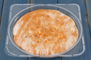 calzone in plastic bag on blue wooden background
