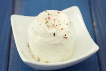 fresh cheese on white plate on blue wooden background