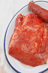 raw marinated pork with chorizo on white dish