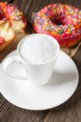 Cappuccino and donuts on a wooden table
