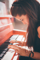 Young beautiful caucasian girl playing piano
