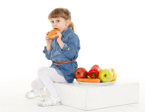 Child with hamburger and fruits.