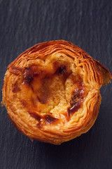 traditional portuguese cookies pasteis de nata on black wooden background