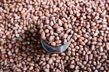 a cup of nuts, a lots of nuts in background