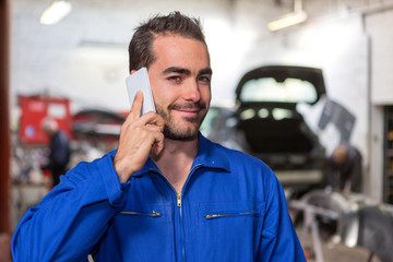 Young attractive mechanic working at the garage