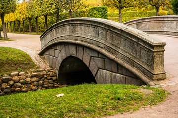 Arch bridge and fish channel in catherine park in autumn