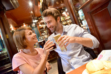 Young couple in restaurant cheering with drinks