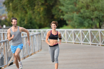 Couple of joggers running on bridge