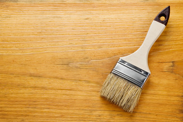 Paint brush on varnished wooden board with place for text