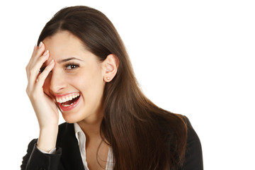 An attractive woman laughing with her hand on her face.