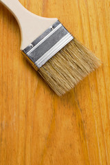 Paint brush on varnished wooden board with place for text