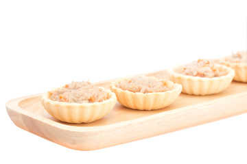 Homemade mini of tuna spread topping in wooden tray on white bac