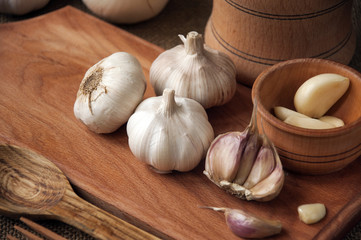 Garlic on cutting board , close-up on sacking. burlap background