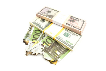 dollars and burned euros bills on white