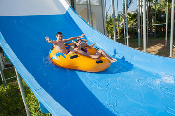 Couple sliding down a water slide