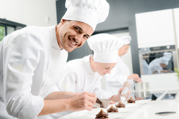 portrait of a handsome young man professional pastry cook preparing a chocolate dessert