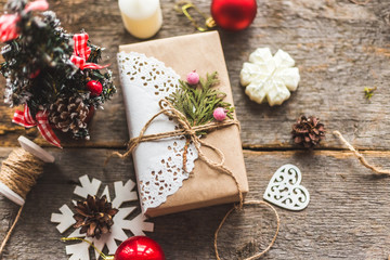 Cozy vintage toned winter holidays Christmas Composition with Gifts Boxes and Balls, Pine Cones Wooden Background