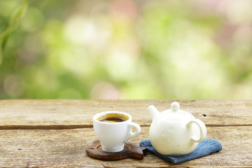 Tea cup with vintage old teapot on wooden table