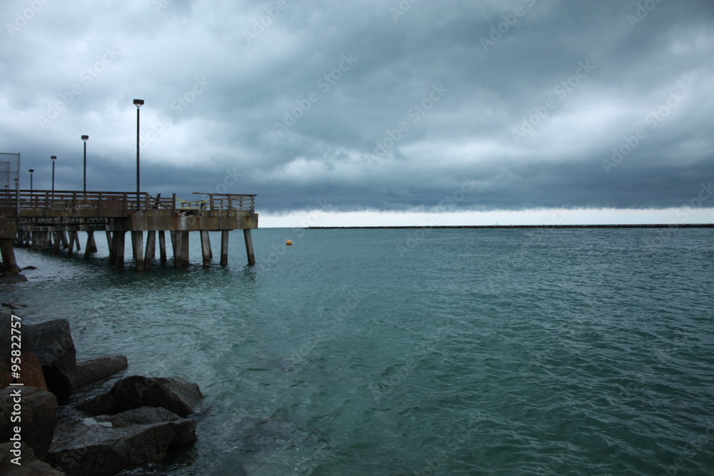 Poster a pier on a stormy day
