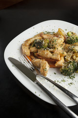 Chicken with vegetables in a white plate