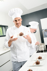 portrait of a handsome young man professional pastry cook preparing a chocolate dessert
