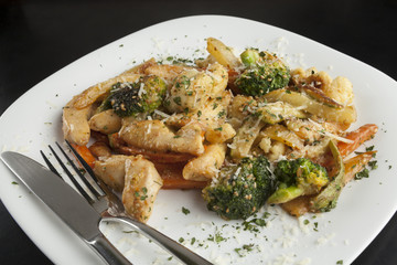 Chicken with vegetables in a white plate