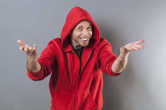 male adolescence concept - smiling middle age wearing a red hooded sweater playing rapper with fun hand gesture,studio