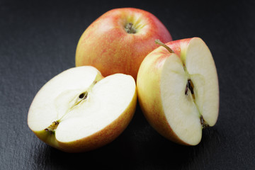 ripe apples sliced on slate board
