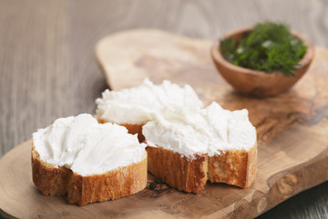 homemade appetizing crostini with soft cheese cream herbs