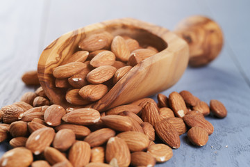 roasted almonds on blue wooden table with scoop