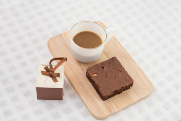 A cup of coffee with brownie cake