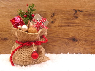 Jutesack mit Geschenken am Holz Hintergrund