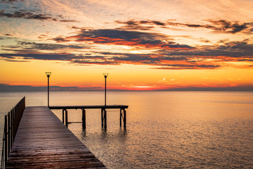 Obraz premium Wooded bridge in the port between sunrise.