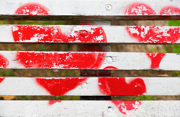 Red hearts painted on a white wooden bench