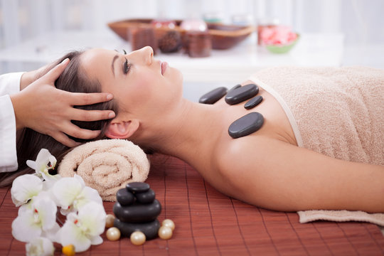 Beautiful woman having a wellness head massage at spa salon