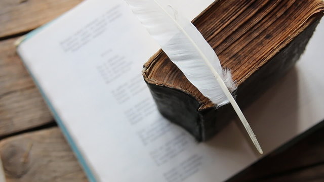 Poet, writer, literature idea. Old book, book of poems and a feather.