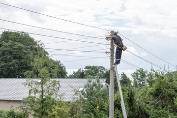 Power company worker is repairing electrical wires.