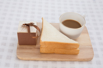 Obraz na płótnie Canvas A cup of coffee with sandwich and gift