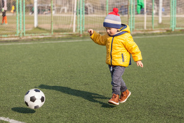 Obraz premium little boy playing with soccer or football ball. sports for exercise and activity.