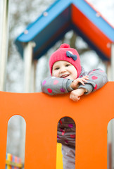 Fototapeta na wymiar Little girl is playing on playground