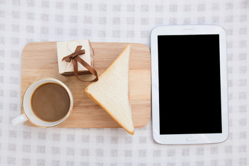Fototapeta na wymiar A cup of coffee with sandwich and tablet